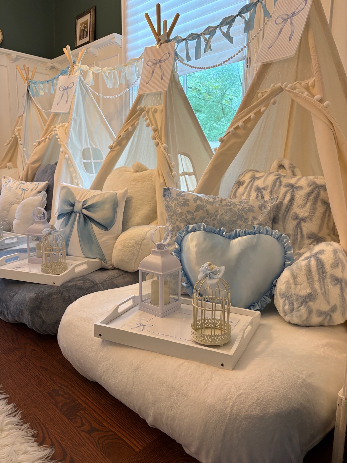 Blue Fancy Chic tent sleepover with blue bow pillows and garland