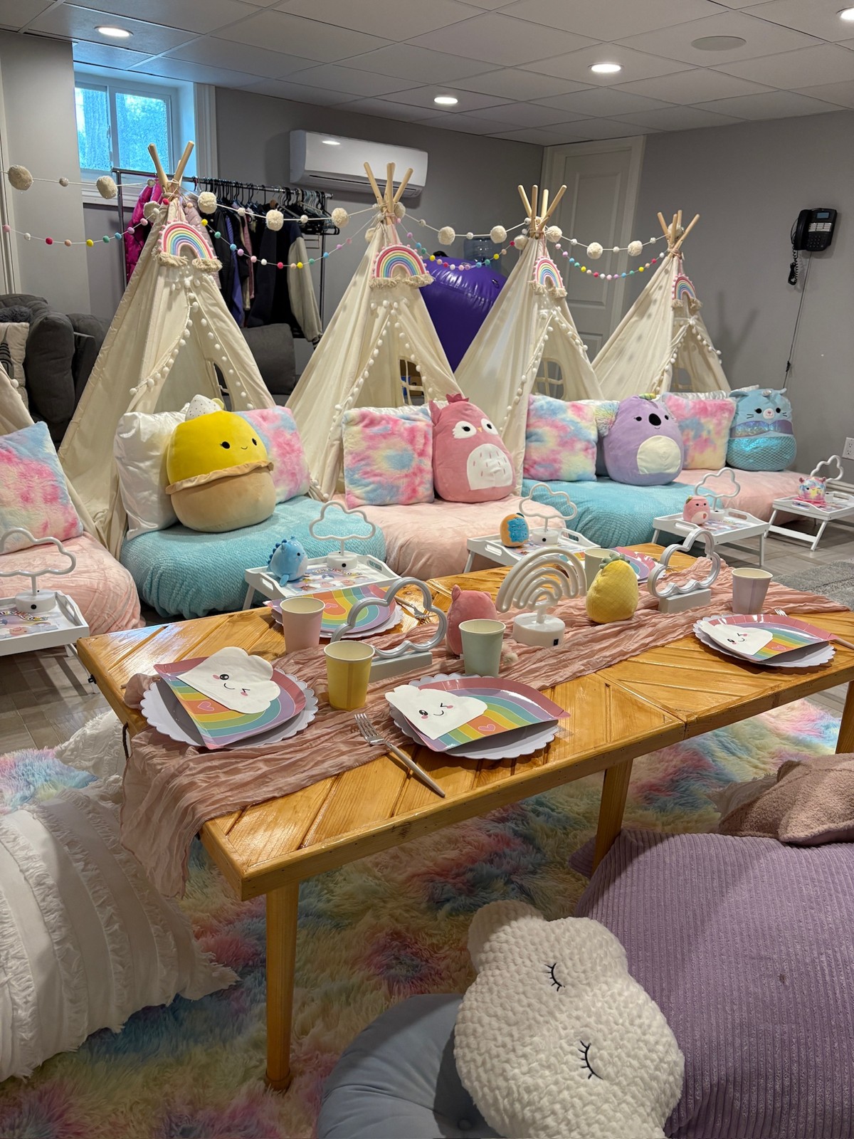 Colorful tent sleepover and picnic table styled together with rainbow decor