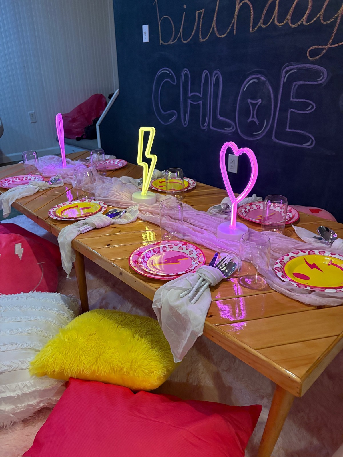 Bright pink and yellow birthday picnic with colorful lights and cushions
