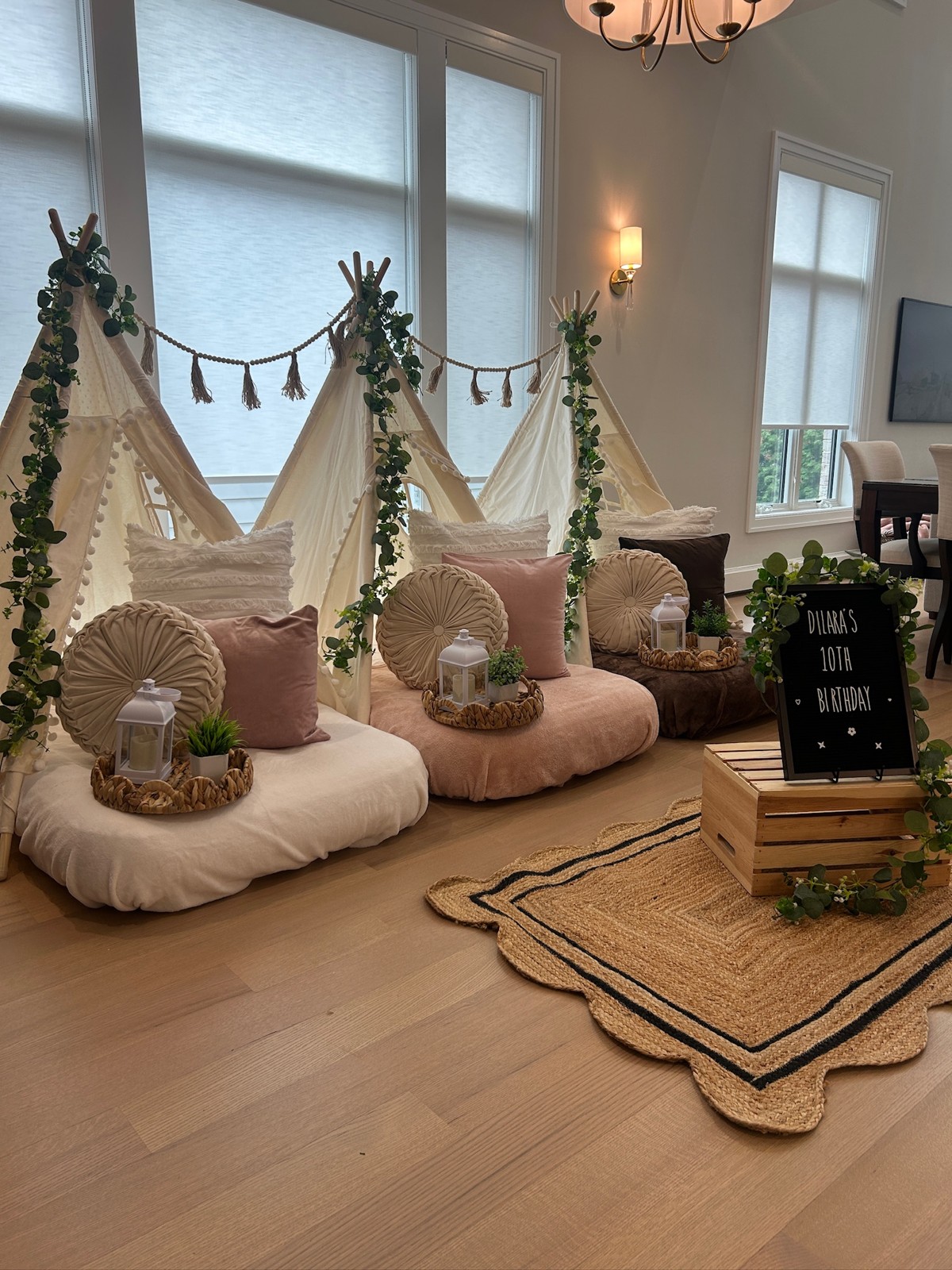 Neutral tent sleepover with greenery and round pillows