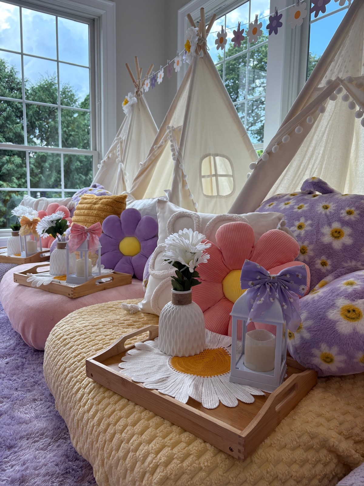 Daisy tent sleepover with colorful flower pillows and styled trays